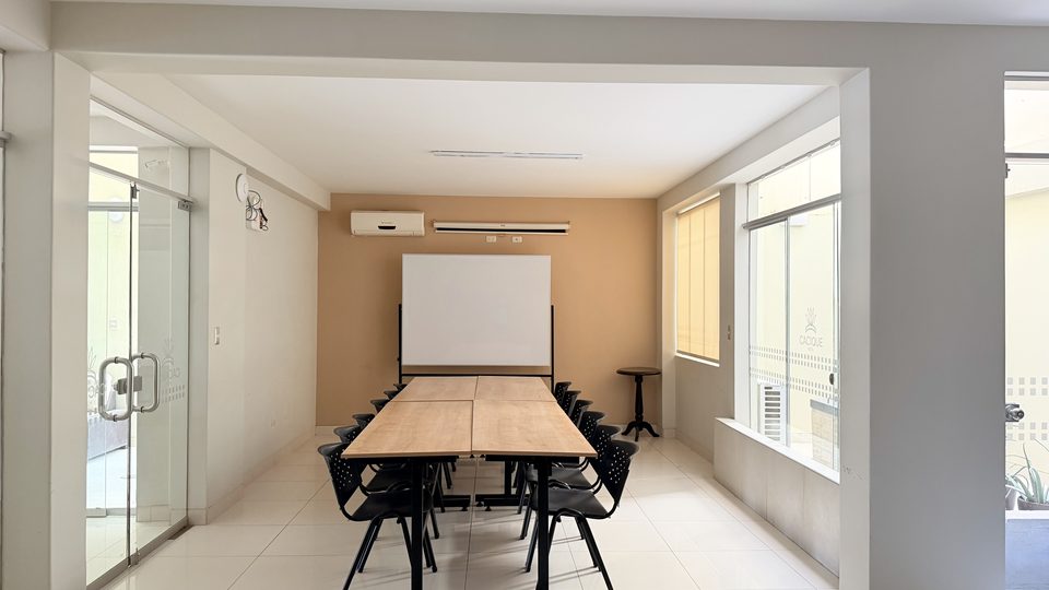 Auditorium at Cacique Hotel, with a work table seating 14 and a projection screen