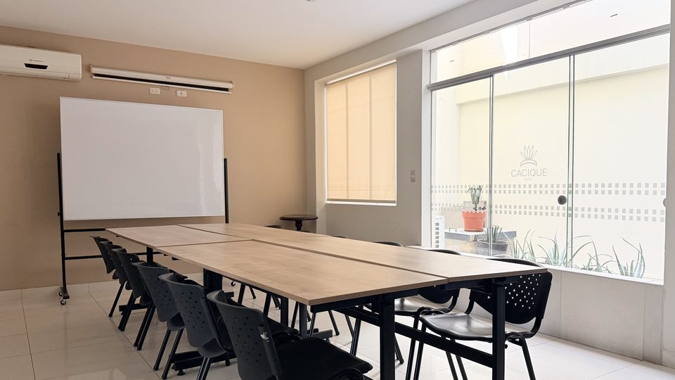 Auditorium at Cacique Hotel with a whiteboard, air conditioning and a street-facing window