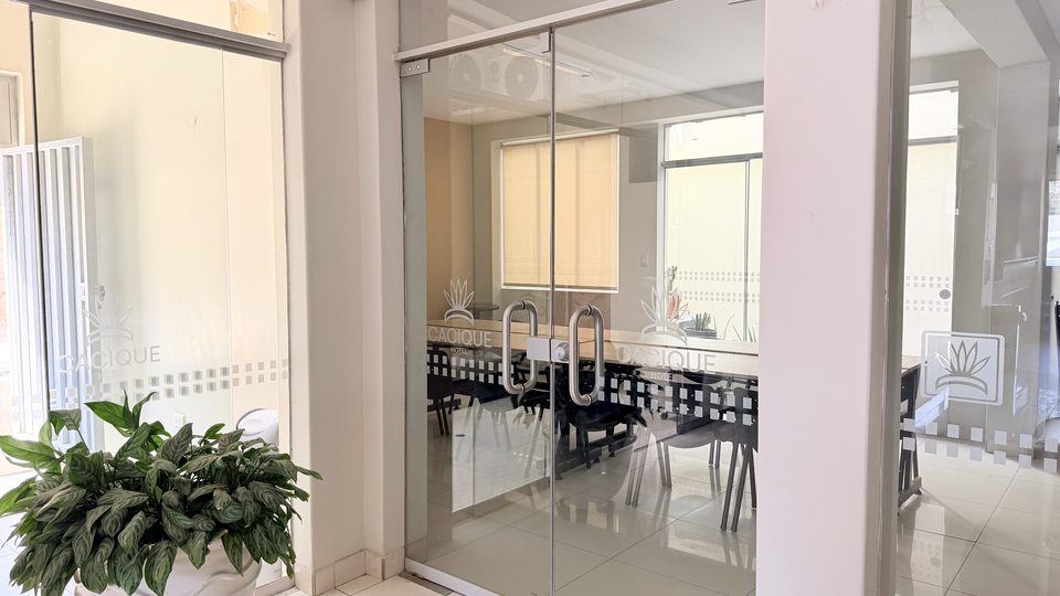 Glass doors of the Cacique Hotel auditorium, with the logo etched on them