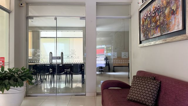 Cacique Hotel interiors: the glazed meeting room seen from the hallway