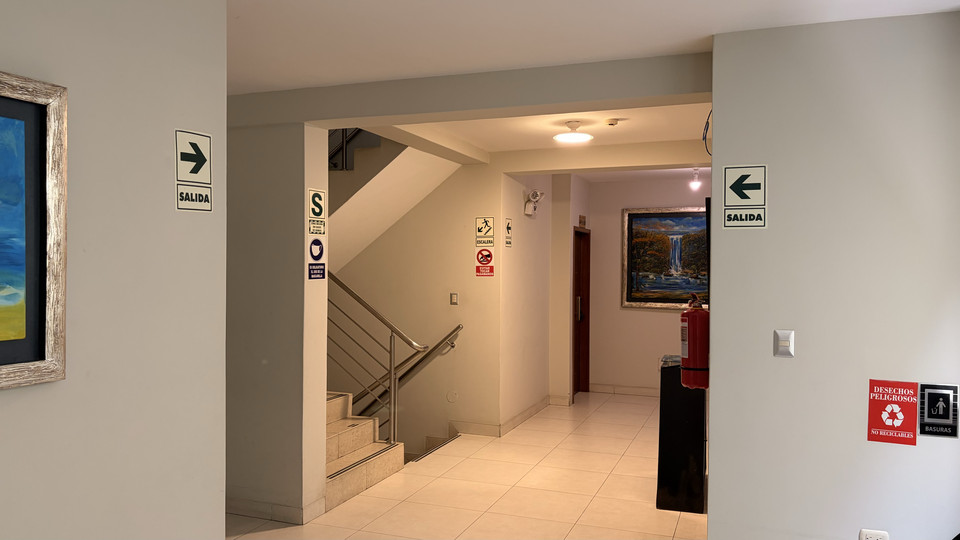 Waiting area in the hotel corridor, with an armchair and exit signage