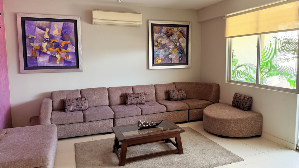 Waiting lounge at the main entrance, with an L-shaped sofa and garden windows