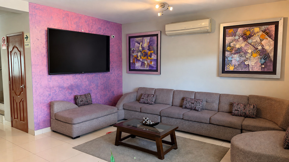 Lobby lounge at Cacique Hotel, with a television and an L-shaped sofa