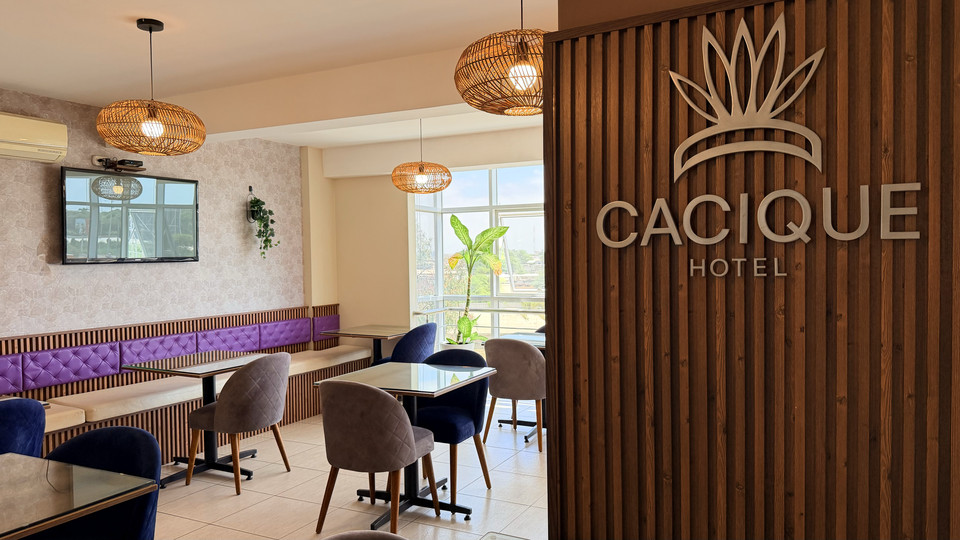 Restaurant dining room next to the wall mural bearing the Cacique Hotel logo